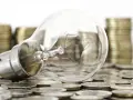 Bombilla sobre monedas, sugiriendo ideas valiosas y técnicas de impresión para la innovación.
