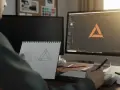 Diseñador gráfico esboza ideas en cuaderno y crea un logo en su computadora. Un buen lugar donde estudiar diseño gráfico.