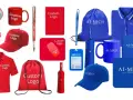 Variedad de productos de marketing personalizables: gorras, polos, tazas, bolígrafos, abanicos, ratones, paraguas, cuadernos y bolsas con logos.