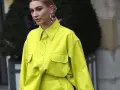 Modelo luce una camisa de **color lima** vibrante, con bolsillos frontales y grandes aros plateados.