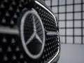Primer plano de la parrilla de un coche con el nuevo logo Mercedes.