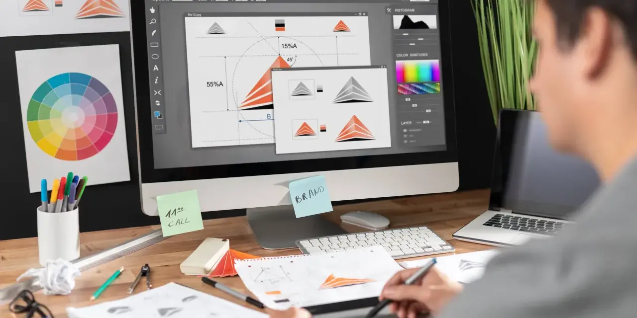 Diseñador trabajando en un programa de diseño gráfico gratis, creando un logo. Se ven bocetos, paleta de colores y notas.