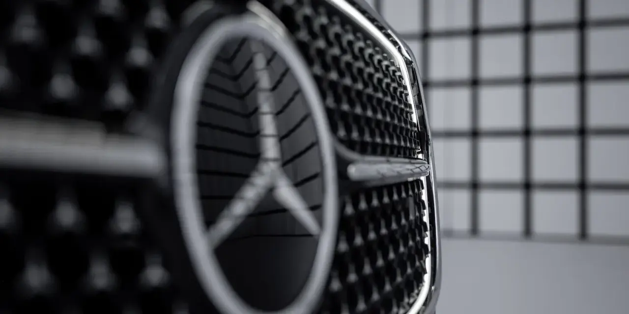 Primer plano de la parrilla de un coche con el nuevo logo Mercedes.