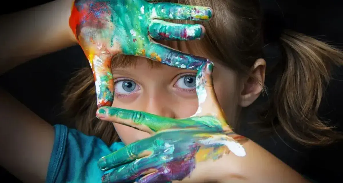 Niña con manos pintadas de colores, creando un marco. Fotografías sin derechos de autor para inspirar tu creatividad.