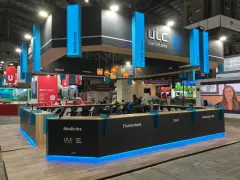 Moderno stand para ferias con iluminación azul, mostrando áreas como Medicina y Fisioterapia. Ideas de stand para ferias que inspiran.