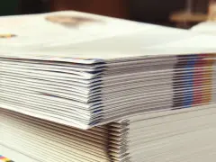 Pilas de folletos recién impresos, un detalle de las curiosidades de la imprenta y la gama de colores CMYK.