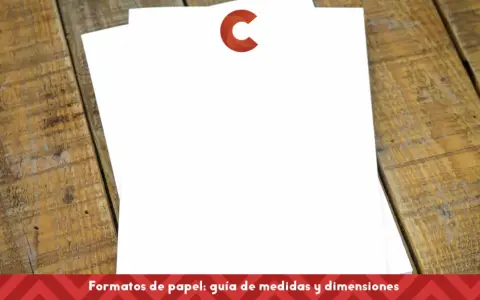 Dos hojas de papel blanco apiladas sobre una mesa de madera. Una tiene un logo rojo en forma de C. Ideal para comparar tamaños din a4 y din a5.