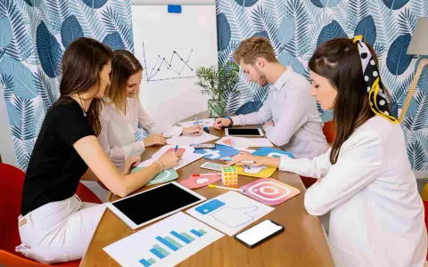 Equipo discutiendo estrategias de marketing digital, con iconos de redes sociales y gráficos. Parecen estar planeando una campaña de "fake out of home".