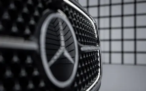 Primer plano de la parrilla de un coche con el nuevo logo Mercedes.