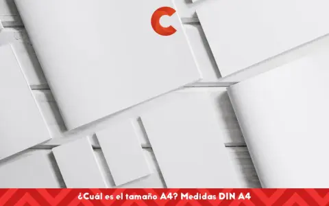 Varias hojas de papel blanco dispuestas sobre una superficie de madera. El texto en la parte inferior pregunta: "¿Cuál es el tamaño A4? Medidas DIN A4".