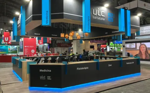 Moderno stand para ferias con iluminación azul, mostrando áreas como Medicina y Fisioterapia. Ideas de stand para ferias que inspiran.