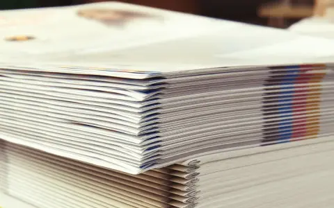 Pilas de folletos recién impresos, un detalle de las curiosidades de la imprenta y la gama de colores CMYK.