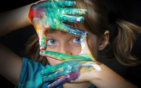 Niña con manos pintadas de colores, creando un marco. Fotografías sin derechos de autor para inspirar tu creatividad.