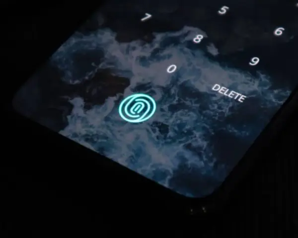 Pantalla de bloqueo de un móvil con fondo de olas. Un icono de huella dactilar brilla en azul. Los tipos móviles evolucionan.