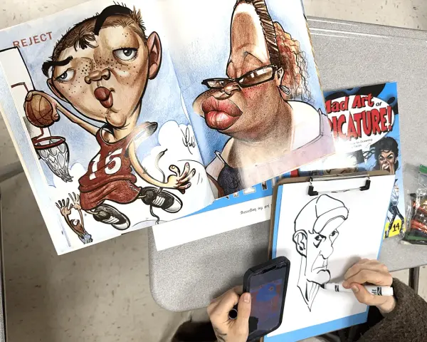 Un libro muestra qué es una caricatura con dibujos exagerados de un jugador de baloncesto y una mujer. Alguien dibuja otra caricatura.
