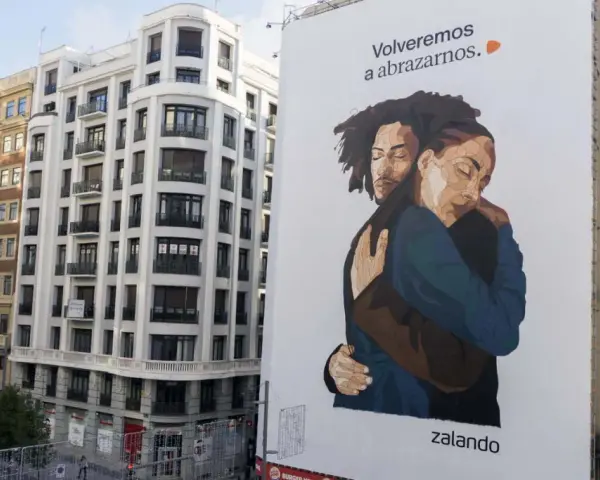 Un abrazo reconfortante en un cartel de Zalando, un ejemplo de street marketing que evoca la cercanía y la esperanza.