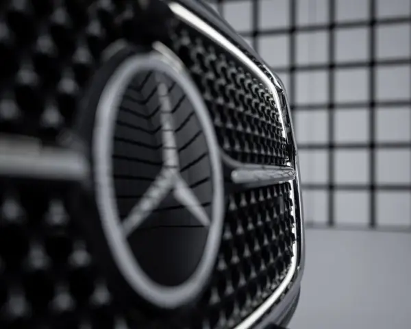 Primer plano de la parrilla de un coche con el nuevo logo Mercedes.