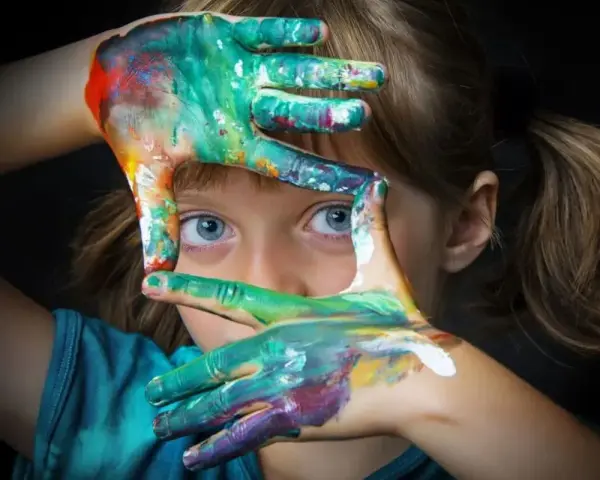 Niña con manos pintadas de colores, creando un marco. Fotografías sin derechos de autor para inspirar tu creatividad.