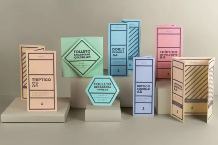 Varios folletos y dípticos de diferentes formas y colores, algunos abiertos y otros cerrados.