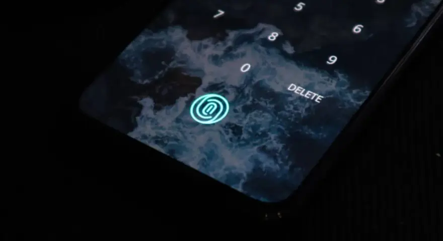 Pantalla de bloqueo de un móvil con fondo de olas. Un icono de huella dactilar brilla en azul. Los tipos móviles evolucionan.