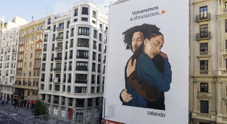 Un abrazo reconfortante en un cartel de Zalando, un ejemplo de street marketing que evoca la cercanía y la esperanza.