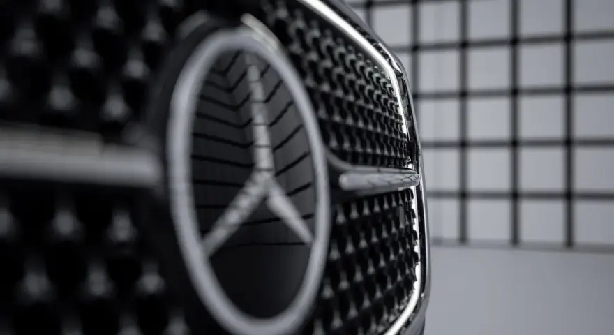 Primer plano de la parrilla de un coche con el nuevo logo Mercedes.
