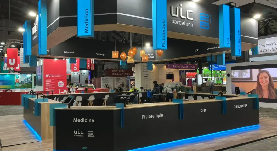 Moderno stand para ferias con iluminación azul, mostrando áreas como Medicina y Fisioterapia. Ideas de stand para ferias que inspiran.