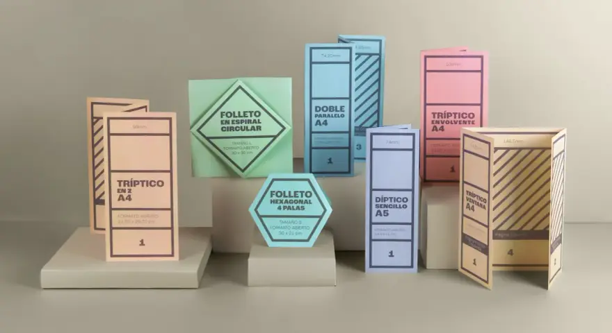 Varios folletos y dípticos de diferentes formas y colores, algunos abiertos y otros cerrados.