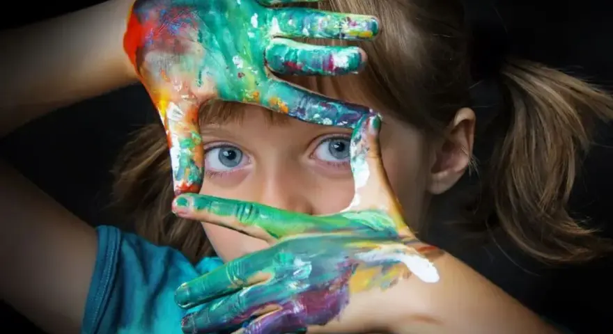 Niña con manos pintadas de colores, creando un marco. Fotografías sin derechos de autor para inspirar tu creatividad.