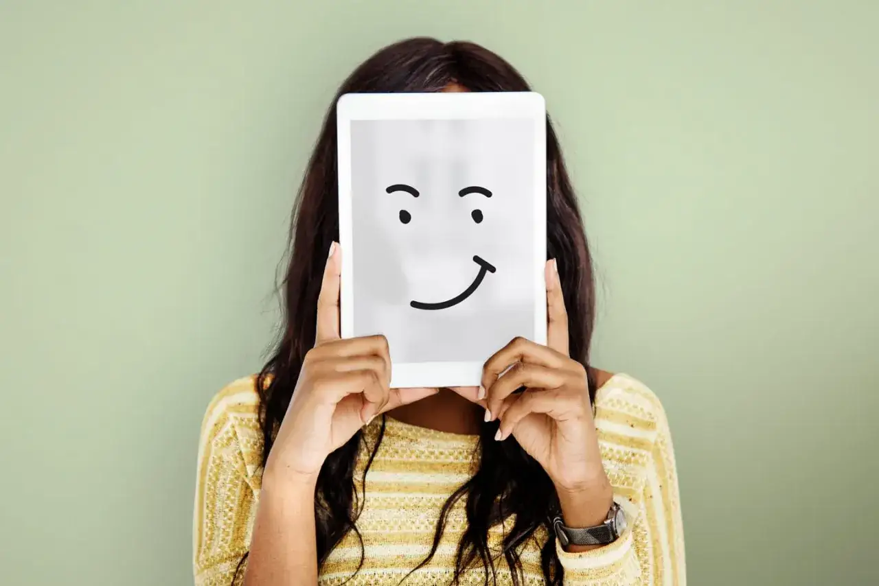 Mujer con tablet que muestra una cara sonriente, reflejando la felicidad de una love brand.